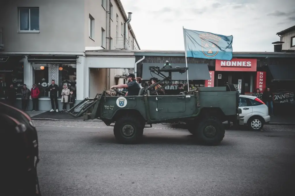 People Driving A Land Rover Series I In The Street