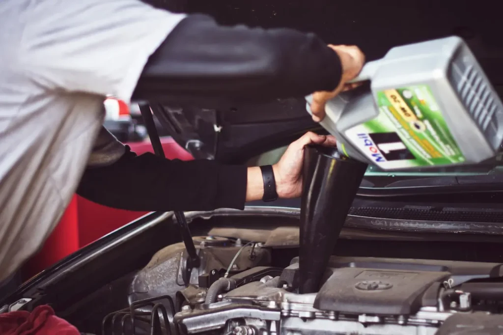 Mechanic Putting Oil In Engine